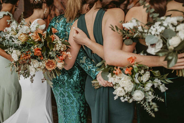 A group of bridesmaids standing together holding bouquets