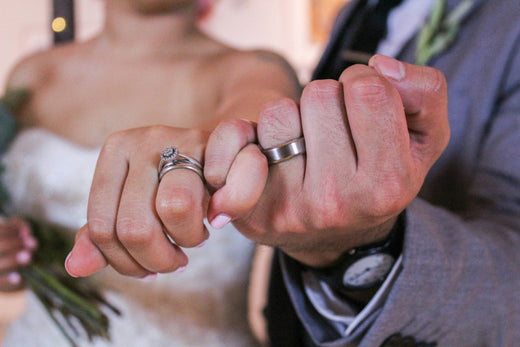 A married couple’s hands with unique wedding bands