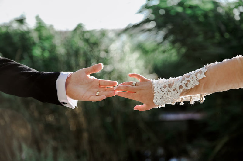 A bride and groom touching hands